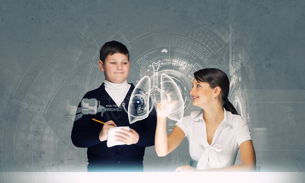 Woman teacher and boy at lesson touching media screen